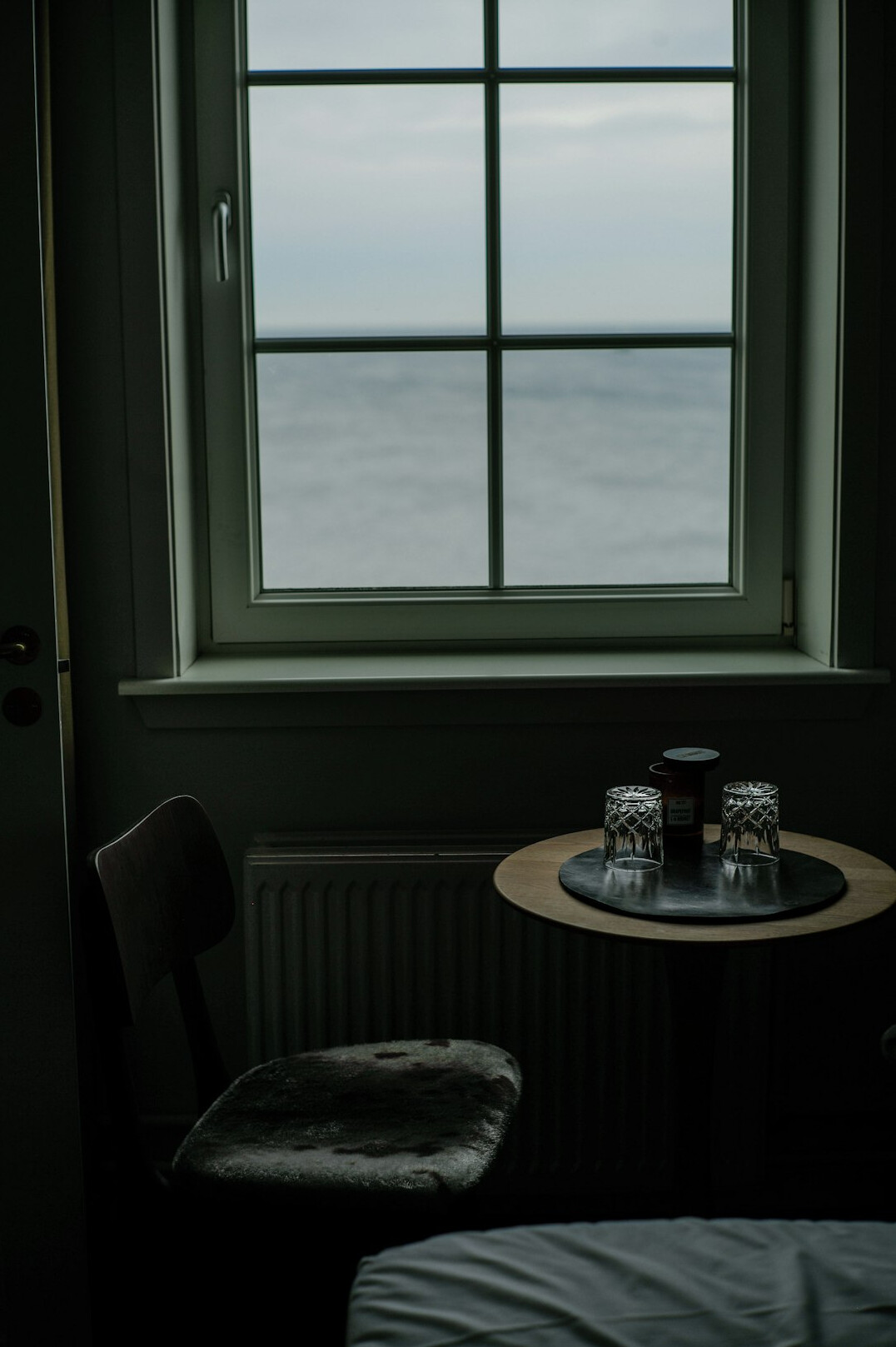 Elderly Danish woman sitting by her window with tea